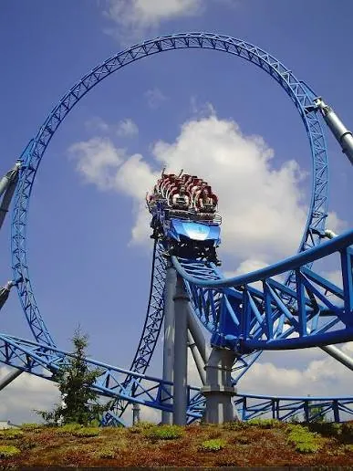 Blue looping rollercoaster train at the top of a vertical loop